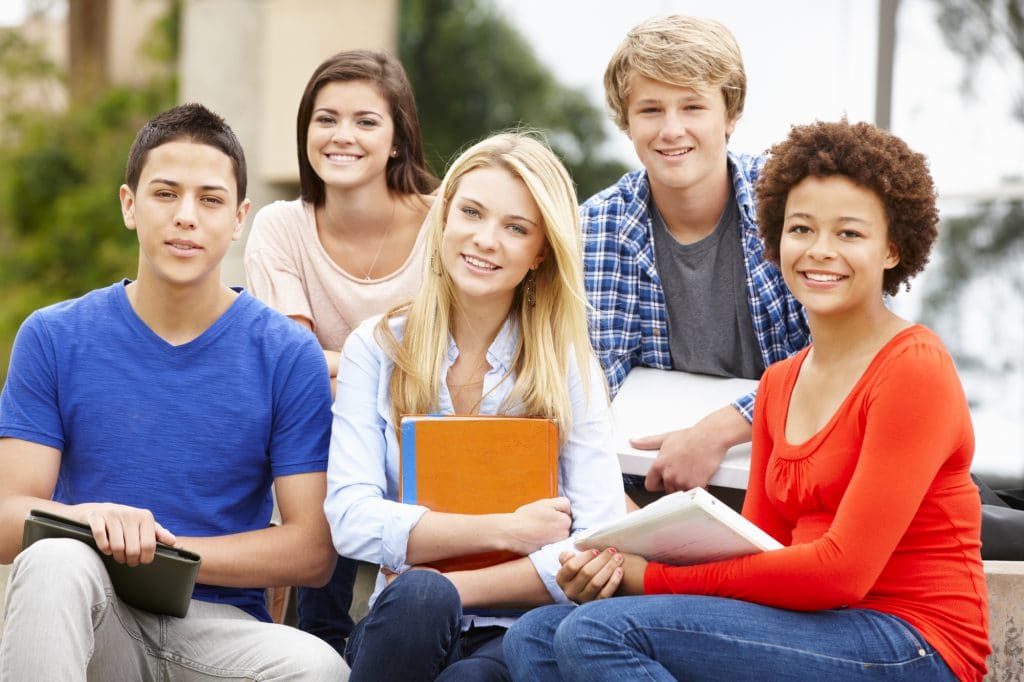 Multi racial student group sitting outdoors | Tomatis® New Zealand
